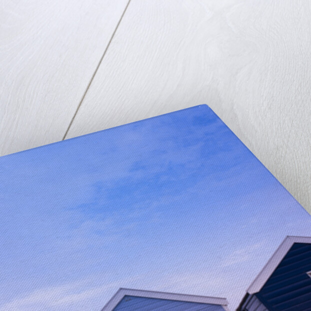 Beach huts in a row against sky by Assaf Frank